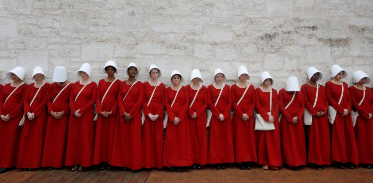 Women dressed as handmaids promoting the Hulu original series "The Handmaid's Tale" stand along a public street during the South by Southwest (SXSW) Music Film Interactive Festival 2017 in Austin, Texas, U.S., March 11, 2017. REUTERS/Brian Snyder - RTX30ML9